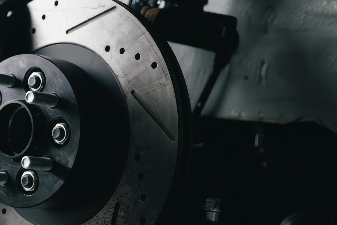 Close-up of a new slotted and drilled brake rotor on a vehicle